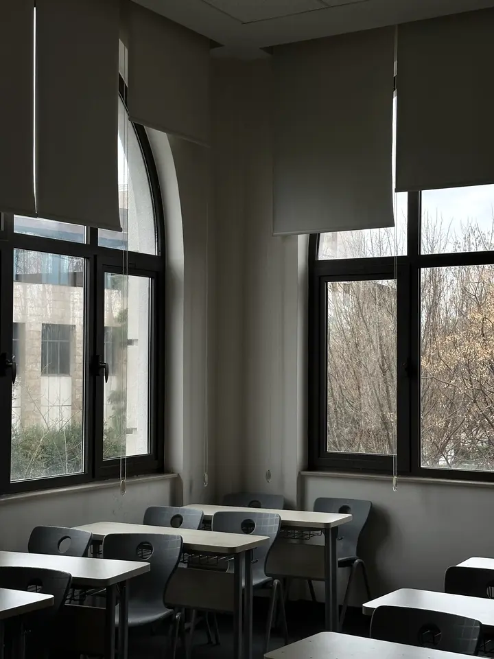 Aula vacía con pupitres junto a ventanales