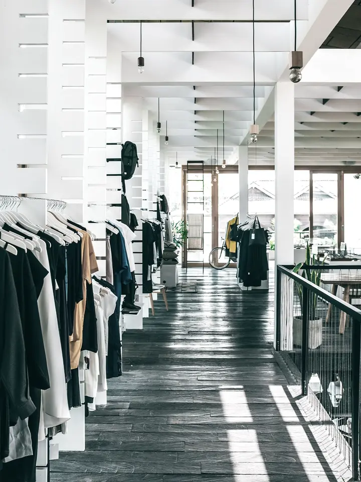 Interior de una tienda de ropa con perchas y luz natural